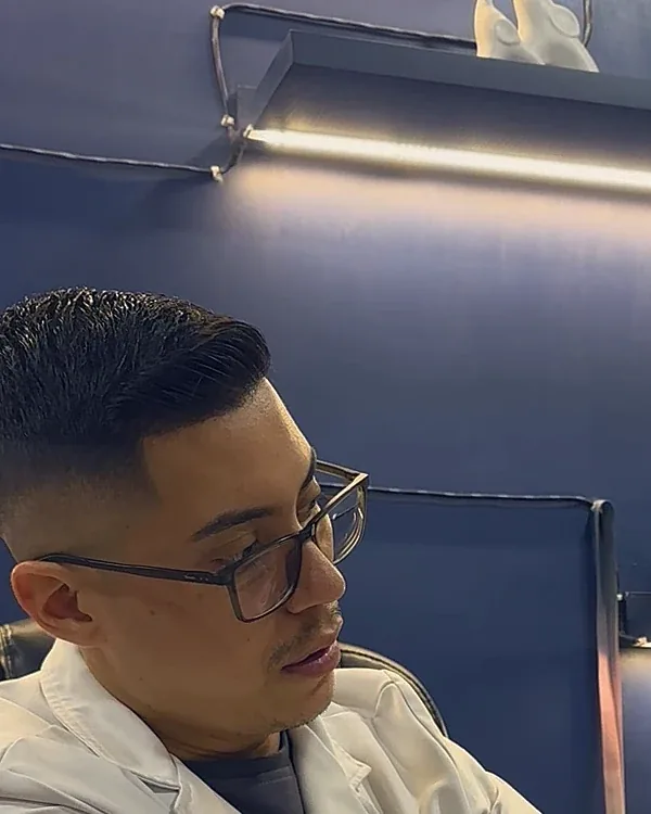 Perfil del Dr. Sanz atendiendo en su consultorio azul noche.