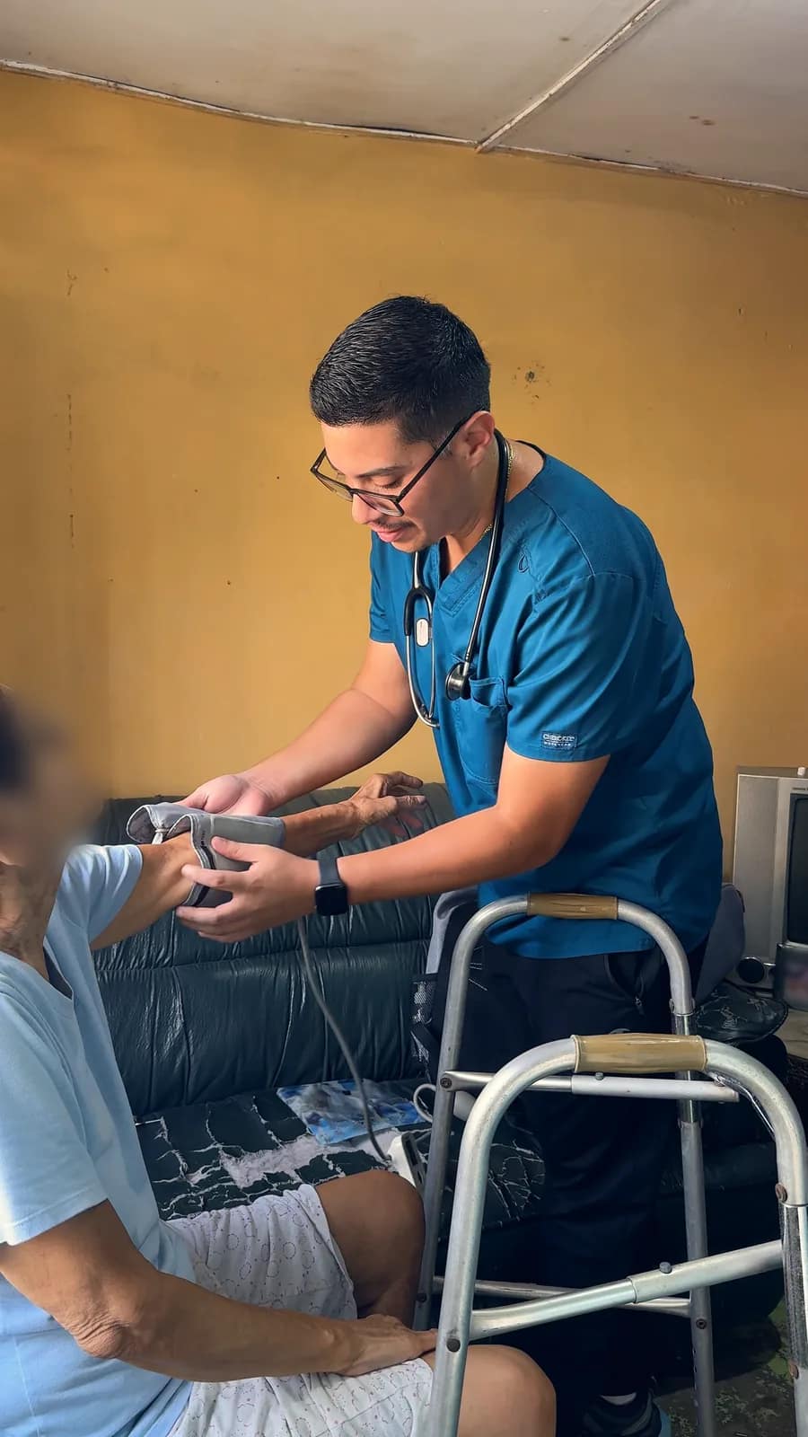 El doctor toma la presión arterial a una paciente adulta mayor.